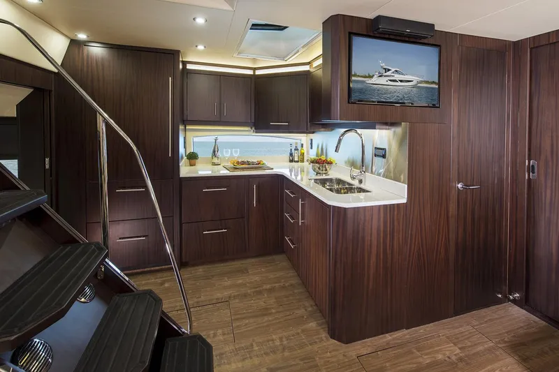 Slide: The Image of 2016 Regal 53 Sport Coupe interior with seating and table, illuminated by blue lighting. - 7