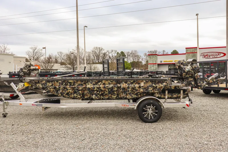 Slide: The Image of 2026 Excel 1751 F4 camo boat on trailer, parked outdoors. - 1