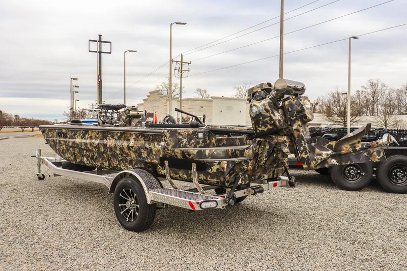 Slide: The Image of Camo-patterned 2026 Excel 1751 F4 boat on trailer, parked outdoors. - 2