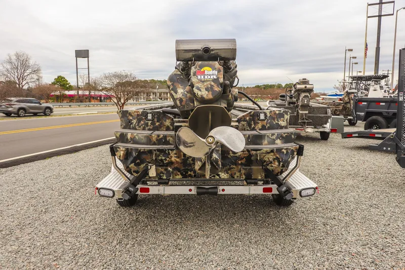 Slide: The Image of Camouflage-patterned 2026 Excel 1751 F4 boat with propeller, parked on gravel near road. - 3
