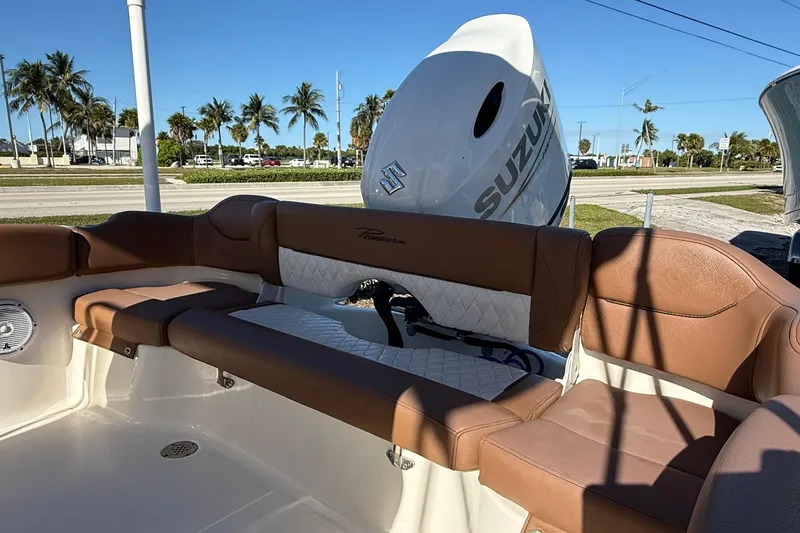 Slide: The Image of 2023 Pioneer 202 Islander boat interior with brown seating and Suzuki engine. - 11