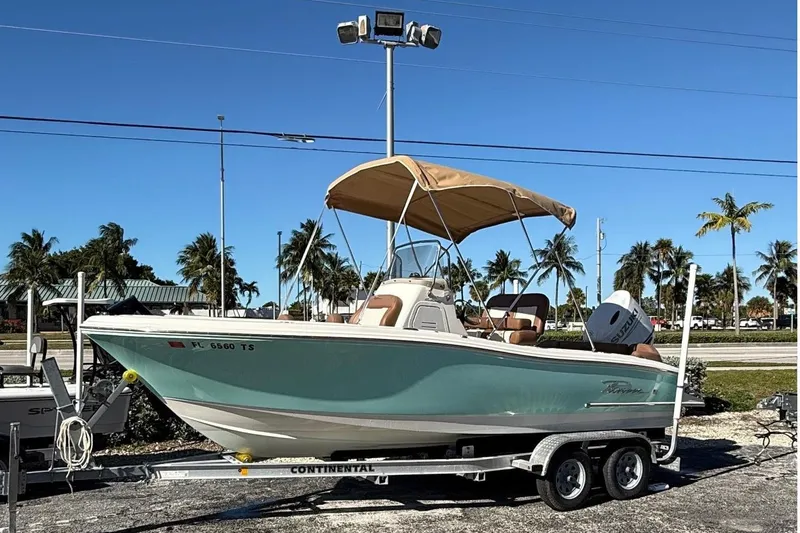 The Image of 2023 Pioneer 202 Islander boat on trailer, sunny day, palm trees in background. - 2