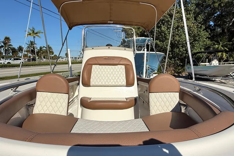 Slide: The Image of 2023 Pioneer 202 Islander boat interior with tan and white seating, sunny day. - 6