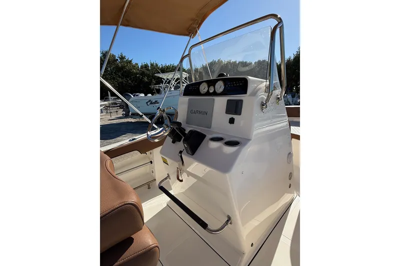 Slide: The Image of 2023 Pioneer 202 Islander boat console with Garmin navigation and brown seating. - 8