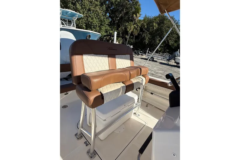 Slide: The Image of 2023 Pioneer 202 Islander boat seat with brown and white upholstery, outdoor setting. - 9