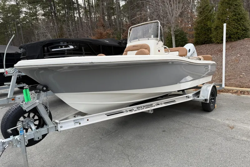 Slide: The Image of 2026 Pioneer 180 Islander boat on trailer, parked outdoors with trees in background. - 1