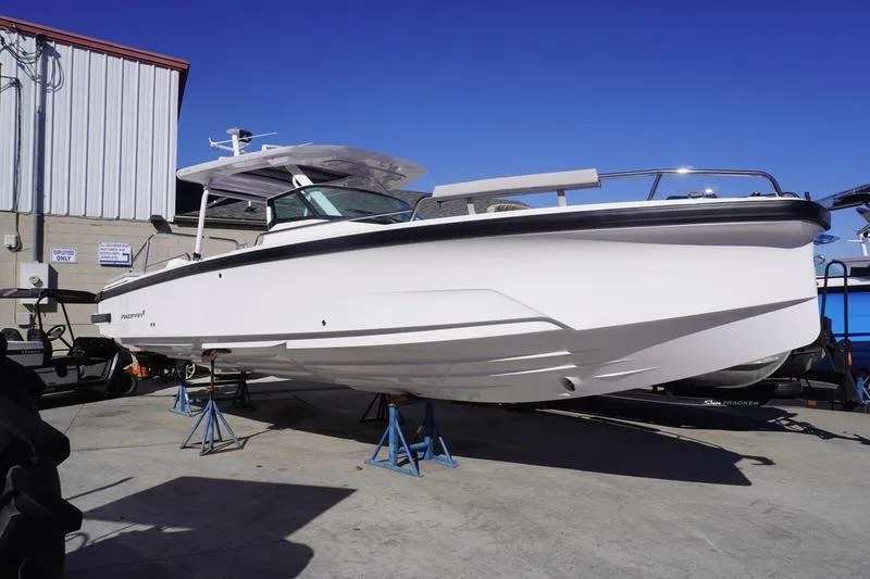 Slide: The Image of 2025 Axopar 29 Sun-Top boat on stands, outdoor display. - 0