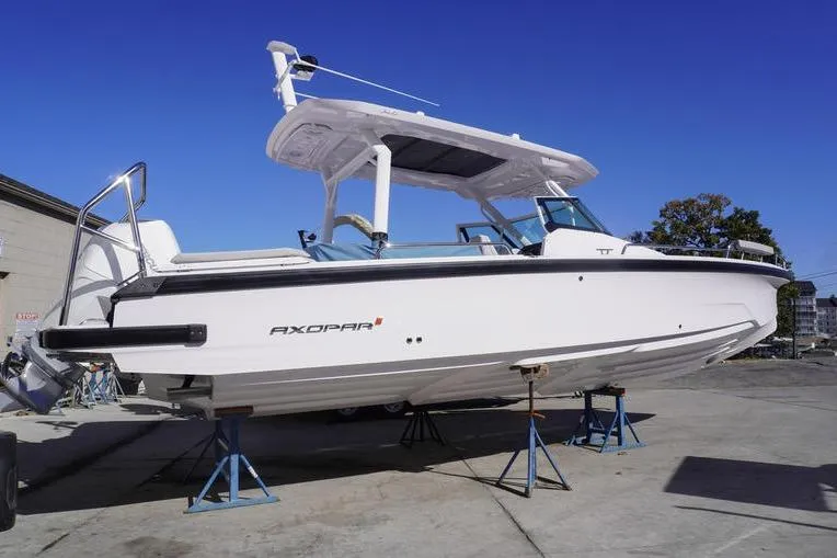 Slide: The Image of 2025 Axopar 29 Sun-Top boat on stands, side view, outdoors. - 1