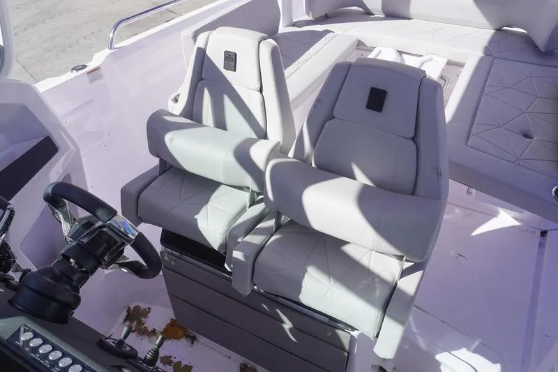 Slide: The Image of 2025 Axopar 29 Sun-Top boat interior with dual seats and steering wheel. - 11