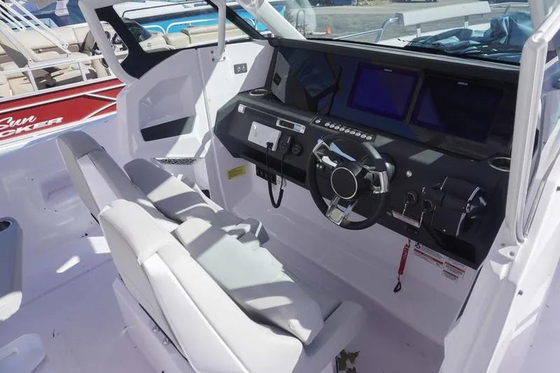 Slide: The Image of 2025 Axopar 29 Sun-Top boat cockpit with modern steering and dual screens. - 12