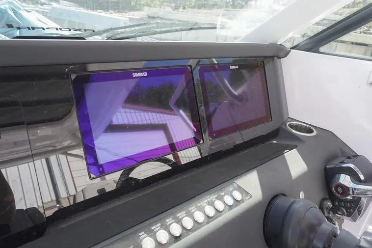 Slide: The Image of 2025 Axopar 29 Sun-Top dashboard with dual Simrad displays and control panel. - 13