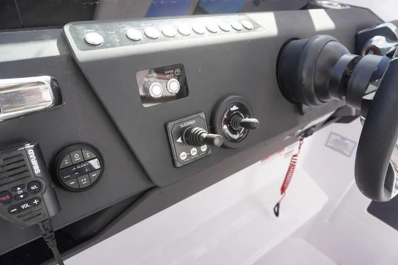 Slide: The Image of Control panel of 2025 Axopar 29 Sun-Top boat with steering wheel and switches. - 14