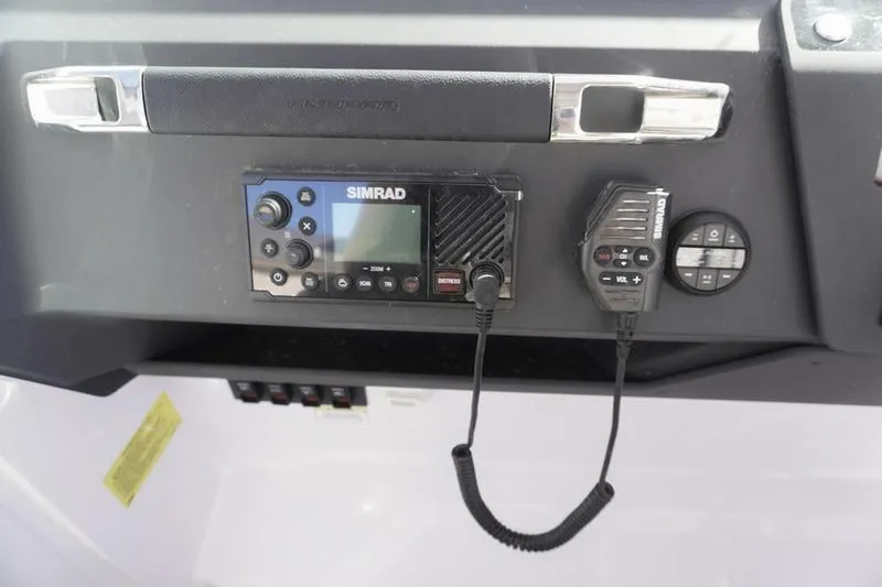 Slide: The Image of 2025 Axopar 29 Sun-Top dashboard featuring Simrad marine radio system. - 15