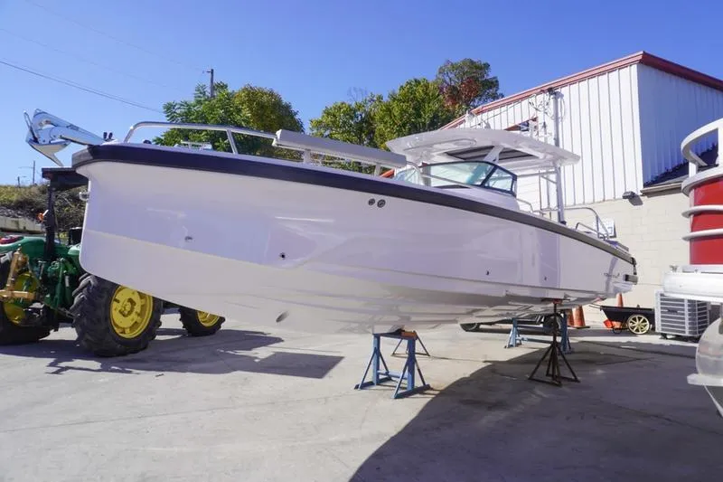 Slide: The Image of 2025 Axopar 29 Sun-Top boat on stands in a sunny outdoor setting. - 2