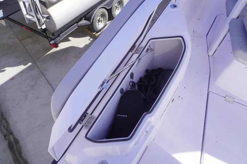 Slide: The Image of 2025 Axopar 29 Sun-Top boat storage compartment with fender and rope. - 21