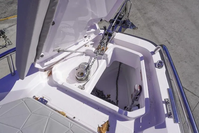 Slide: The Image of Anchor compartment of 2025 Axopar 29 Sun-Top boat with open hatch. - 5