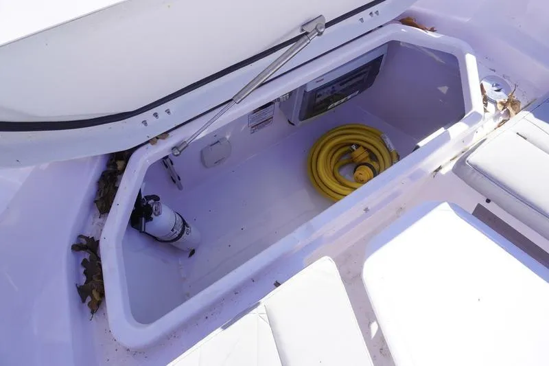 Slide: The Image of Storage compartment of 2025 Axopar 29 Sun-Top boat with hose and fire extinguisher. - 6