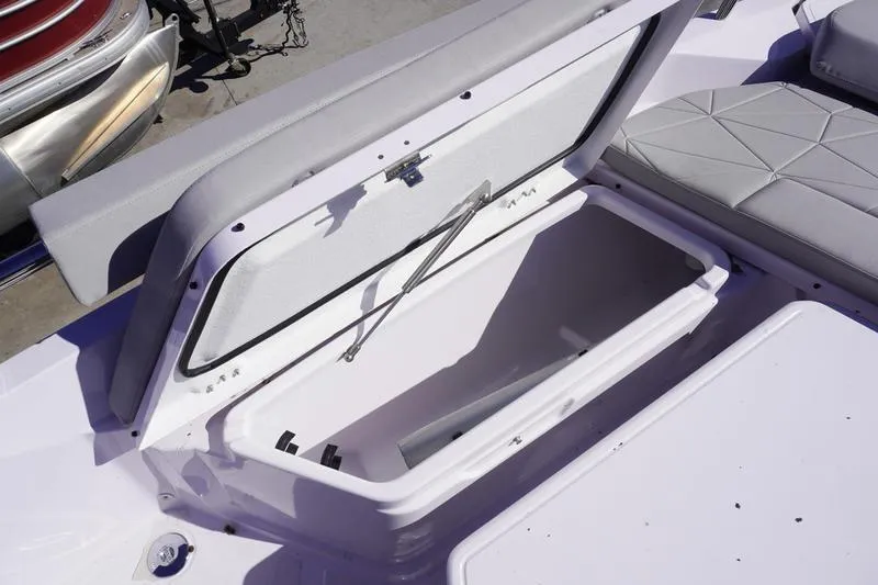 Slide: The Image of Open storage compartment on 2025 Axopar 29 Sun-Top boat, featuring cushioned seating. - 7