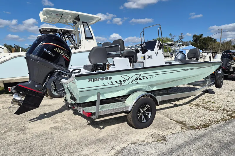 Slide: The Image of 2026 Xpress H20B Bay boat with Yamaha engine on trailer, parked outdoors. - 1