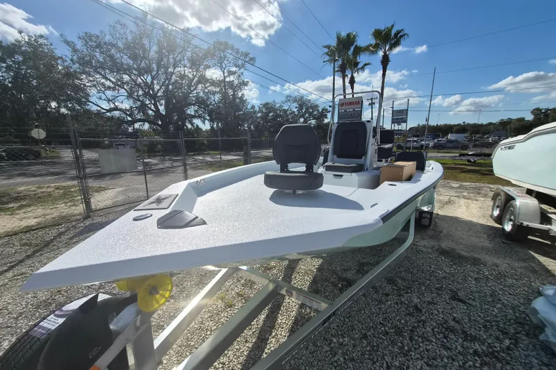 Slide: The Image of 2026 Xpress H20B Bay boat on trailer under sunny sky, surrounded by palm trees. - 4