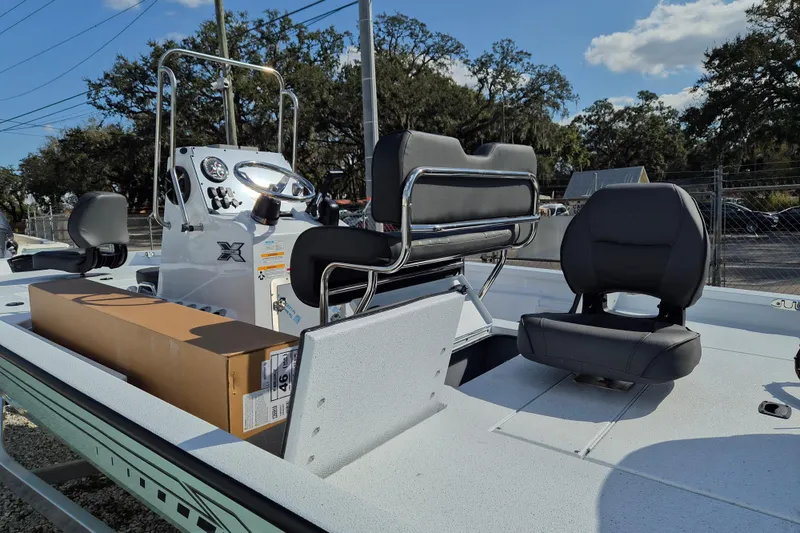 Slide: The Image of 2026 Xpress H20B Bay boat interior with seating and console, under a clear sky. - 5