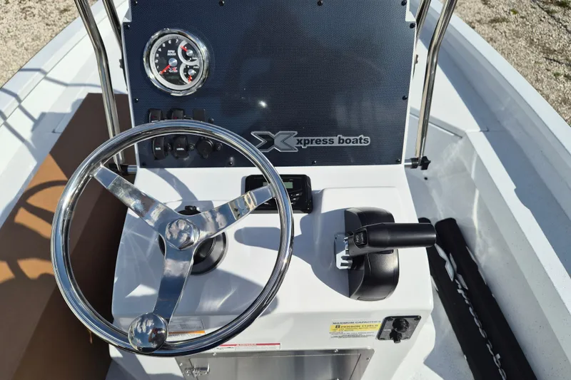 Slide: The Image of Steering console of 2026 Xpress H20B Bay boat with chrome wheel and controls. - 6