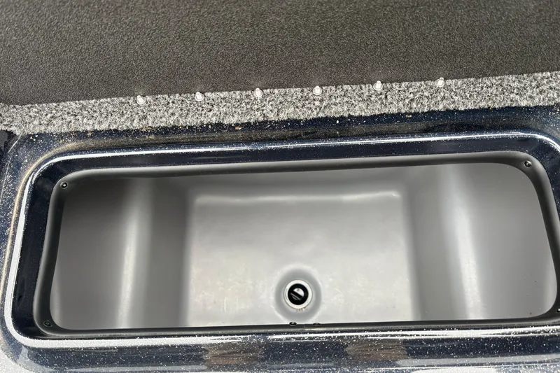Slide: The Image of 2025 Nitro Z17 boat storage compartment with drain plug, carpeted edges. - 15
