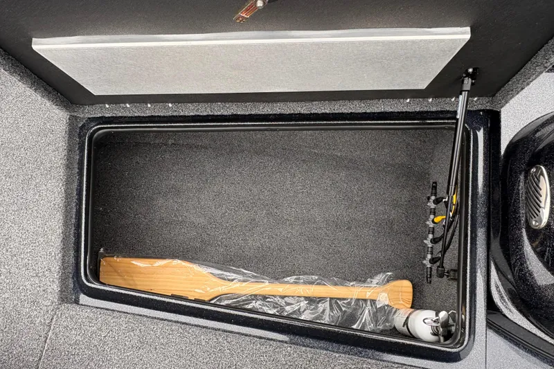 Slide: The Image of Open storage compartment in 2025 Nitro Z17 boat with paddle and fishing rods. - 9