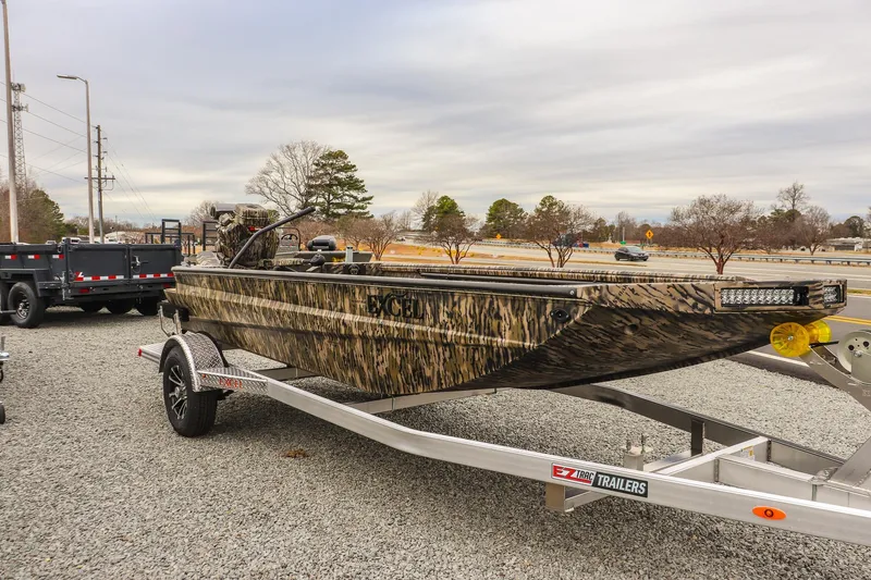 Slide: The Image of 2026 Excel 1754 Shallow Water F4 boat on trailer, camo design, parked outdoors. - 5
