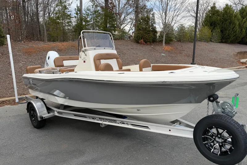 The Image of 2026 Pioneer 180 Islander boat on trailer, parked outdoors, featuring sleek design and modern amenities. - 0