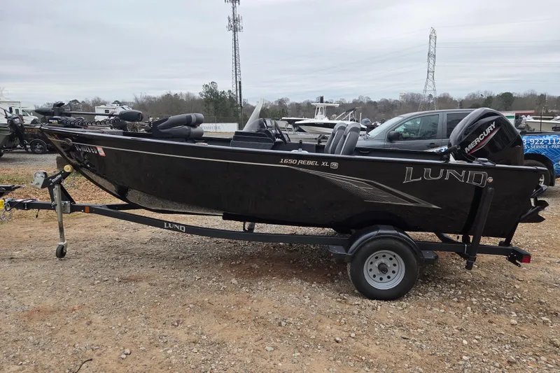 The Image of 2023 Lund 1650 Rebel XL Sport boat on trailer, parked outdoors. - 0