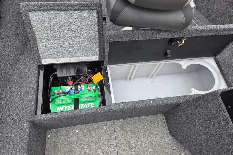Slide: The Image of 2023 Lund 1650 Rebel XL Sport boat battery compartment with Interstate battery and storage area. - 10