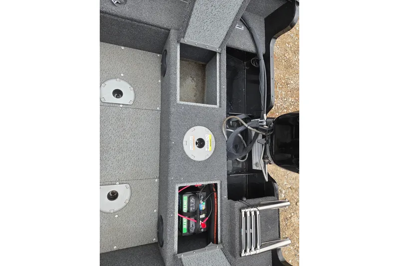 Slide: The Image of 2023 Lund 1650 Rebel XL Sport boat interior with storage compartments and battery. - 13