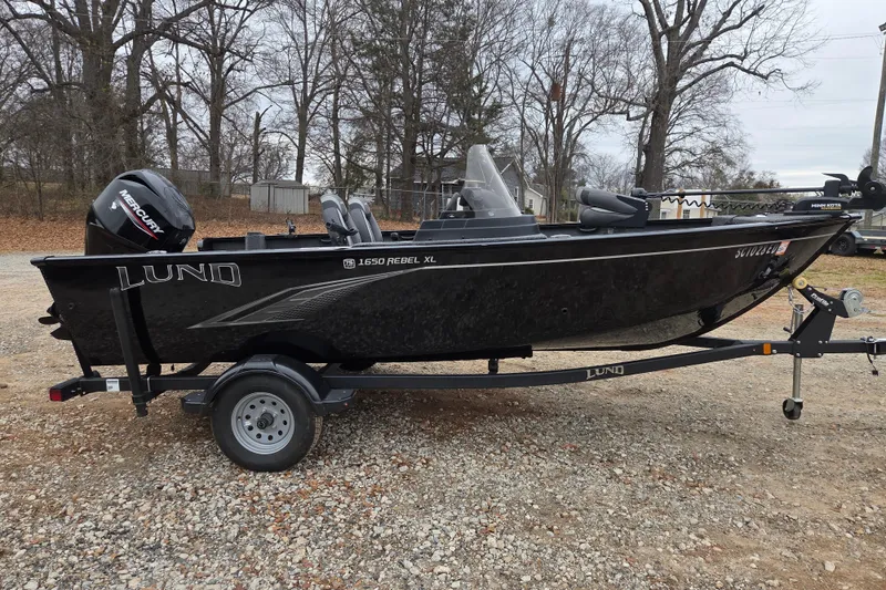 Slide: The Image of 2023 Lund 1650 Rebel XL Sport boat on trailer, parked outdoors. - 3
