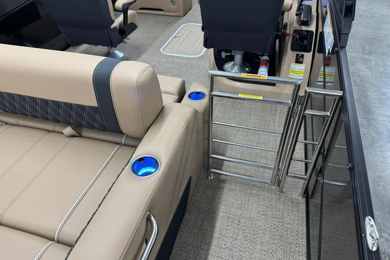 Slide: The Image of 2026 Barletta Lusso 23UCA interior with beige seating, cup holders, and a metal ladder. - 10