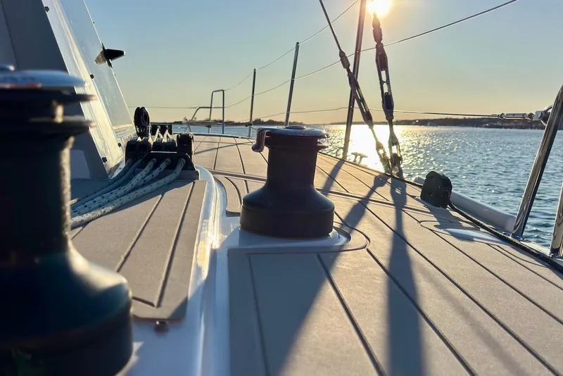 Slide: The Image of 2023 Seawind 1170 sailboat deck at sunset, with ropes and winches visible. - 10