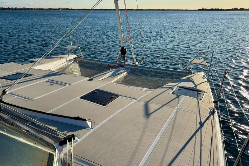 Slide: The Image of 2023 Seawind 1170 catamaran deck on calm ocean waters at sunset. - 11