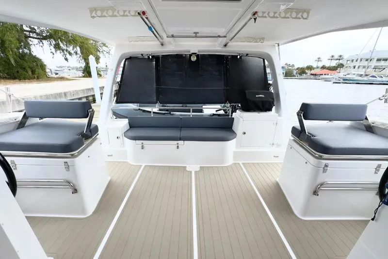 Slide: The Image of 2023 Seawind 1170 catamaran interior with seating, docked by the water. - 16