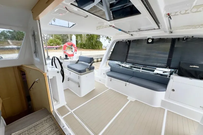 Slide: The Image of 2023 Seawind 1170 catamaran interior with modern seating and steering area. - 17