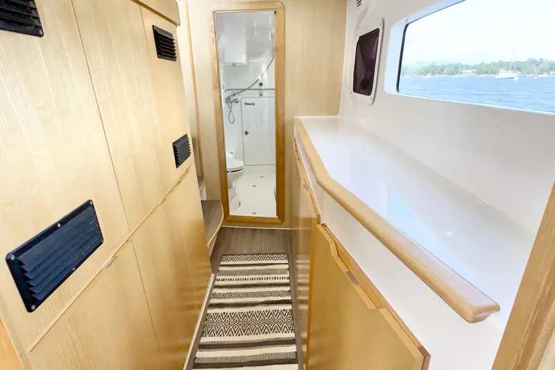 Slide: The Image of 2023 Seawind 1170 yacht interior with wooden cabinets and bathroom view. - 26