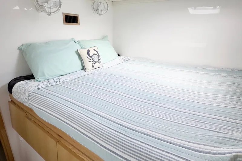 Slide: The Image of Cozy bedroom in 2023 Seawind 1170 yacht with striped bedding and decorative pillow. - 31