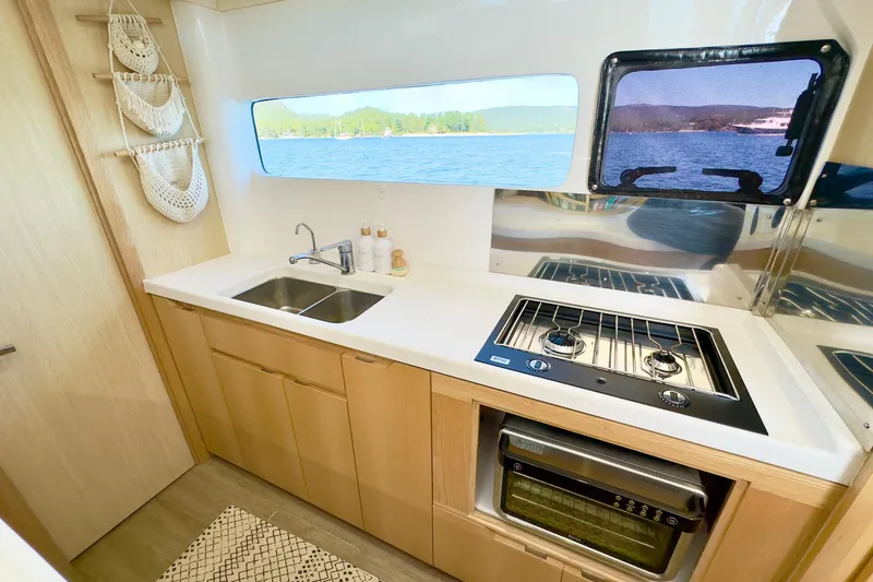 Slide: The Image of Modern kitchen in 2023 Seawind 1170 yacht with stove, sink, and scenic window view. - 36