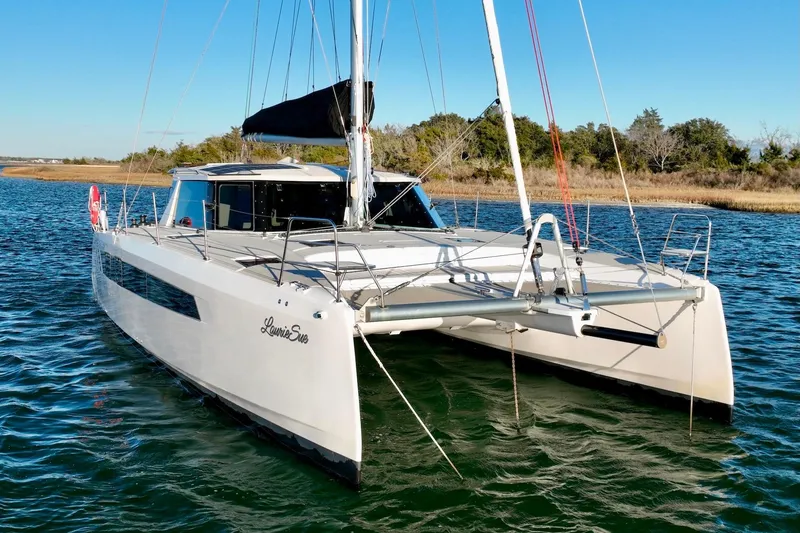 Slide: The Image of 2023 Seawind 1170 catamaran sailing on a calm river with clear blue skies. - 4