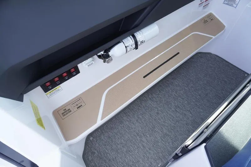 Slide: The Image of 2025 Axopar 29 XC Cross Cabin interior with fire extinguisher and control panel. - 13