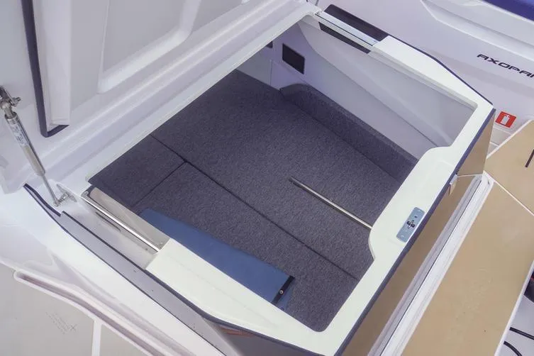 Slide: The Image of 2025 Axopar 29 XC Cross Cabin storage compartment with cushioned interior and sleek design. - 15