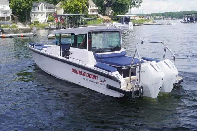 Slide: The Image of 2025 Axopar 29 XC Cross Cabin boat on a lake, featuring twin Mercury engines. - 4