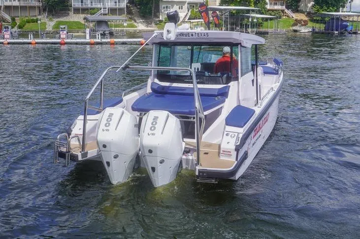 Slide: The Image of 2025 Axopar 29 XC Cross Cabin boat with dual 200 V6 engines on a lake. - 5