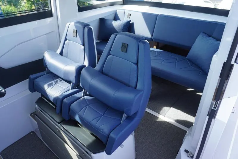 Slide: The Image of Interior of 2025 Axopar 29 XC Cross Cabin with blue seating and modern design. - 6