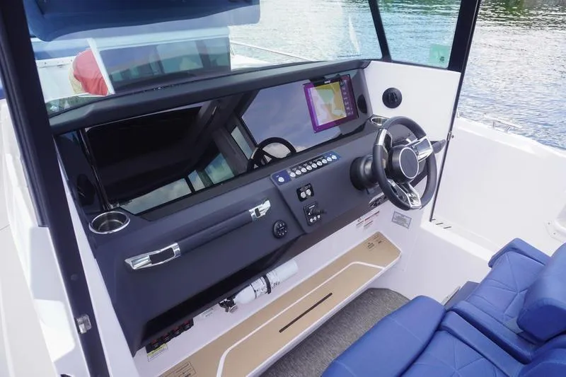 Slide: The Image of 2025 Axopar 29 XC Cross Cabin helm with modern controls and navigation display. - 8