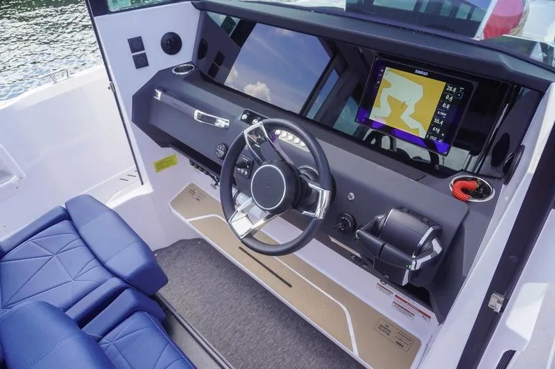 Slide: The Image of 2025 Axopar 29 XC Cross Cabin helm with modern navigation system and blue seating. - 9